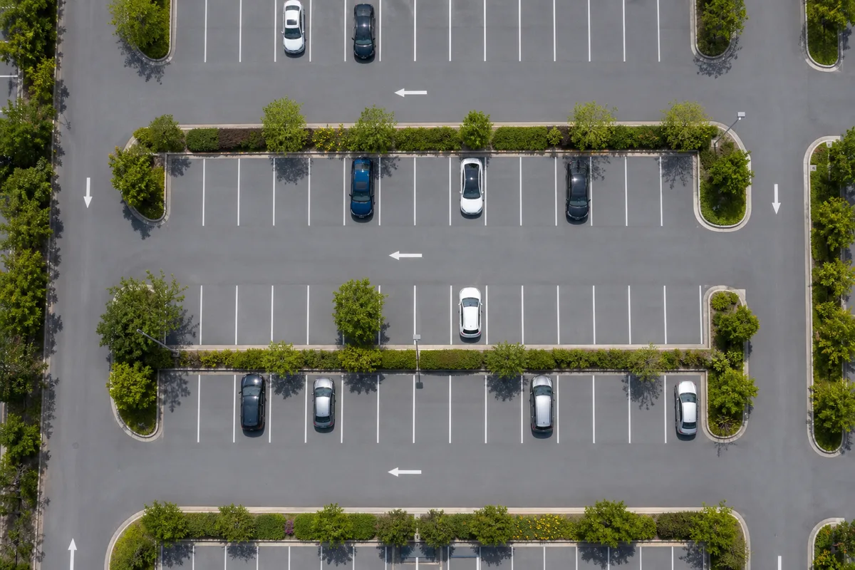 Vue aérienne d’un parking d’entreprise organisé avec allées de circulation et zones de stationnement délimitées
