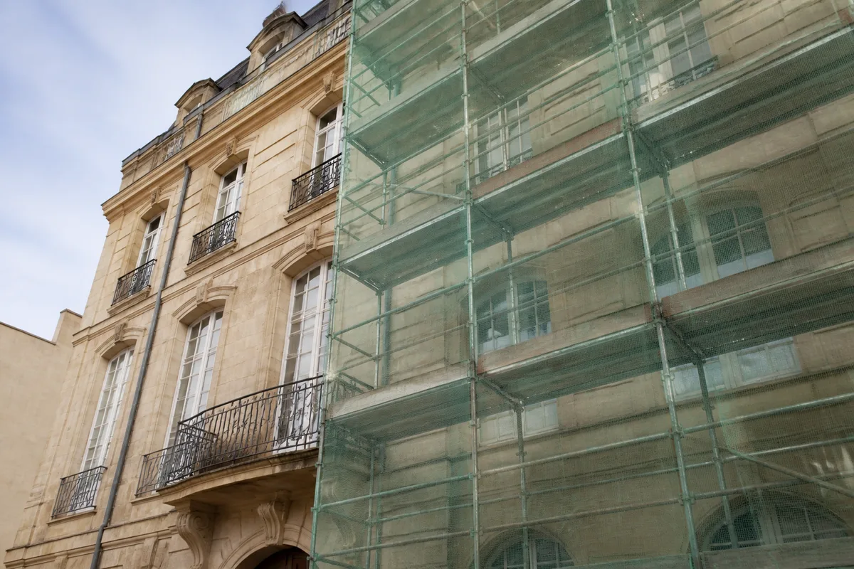 Façade d&rsquo;immeuble ancien en cours de ravalement avec échafaudage